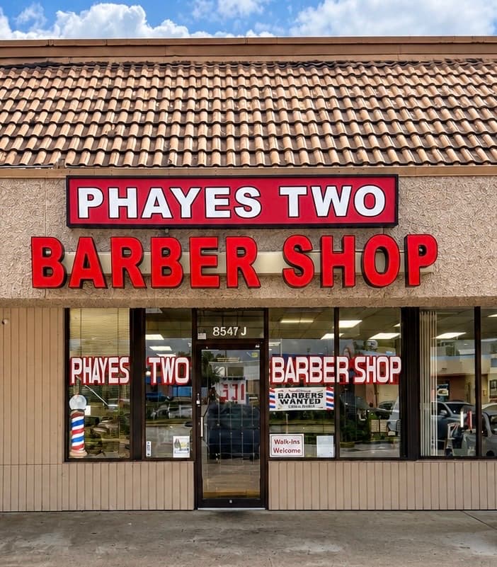 The Phayes Two Barber Shop storefront on West Bellfort — red lettering above the windows, barber pole by the door.